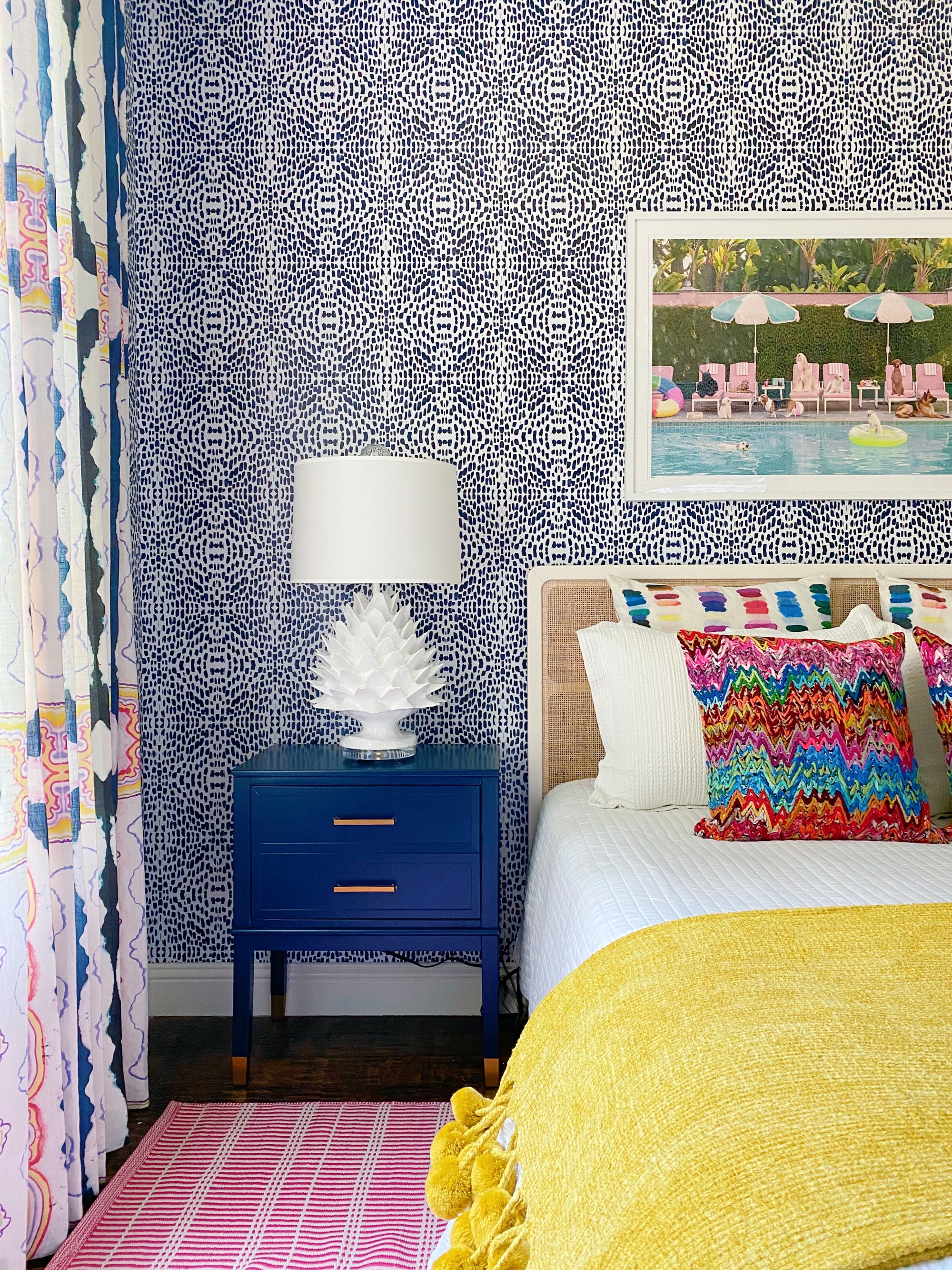 bold table lamp for a bedroom, the artichoke lamp by stray dog designs, on a royal blue side table  next to a modern bed with bold blue patterns wallpaper